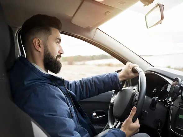 Professional Indian driver opening a sleek black car door for a passenger